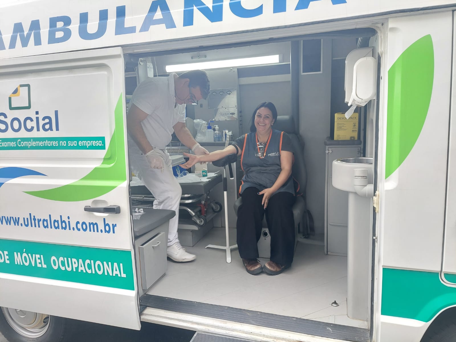 Coleta com paciente sorrindo na unidade móvel